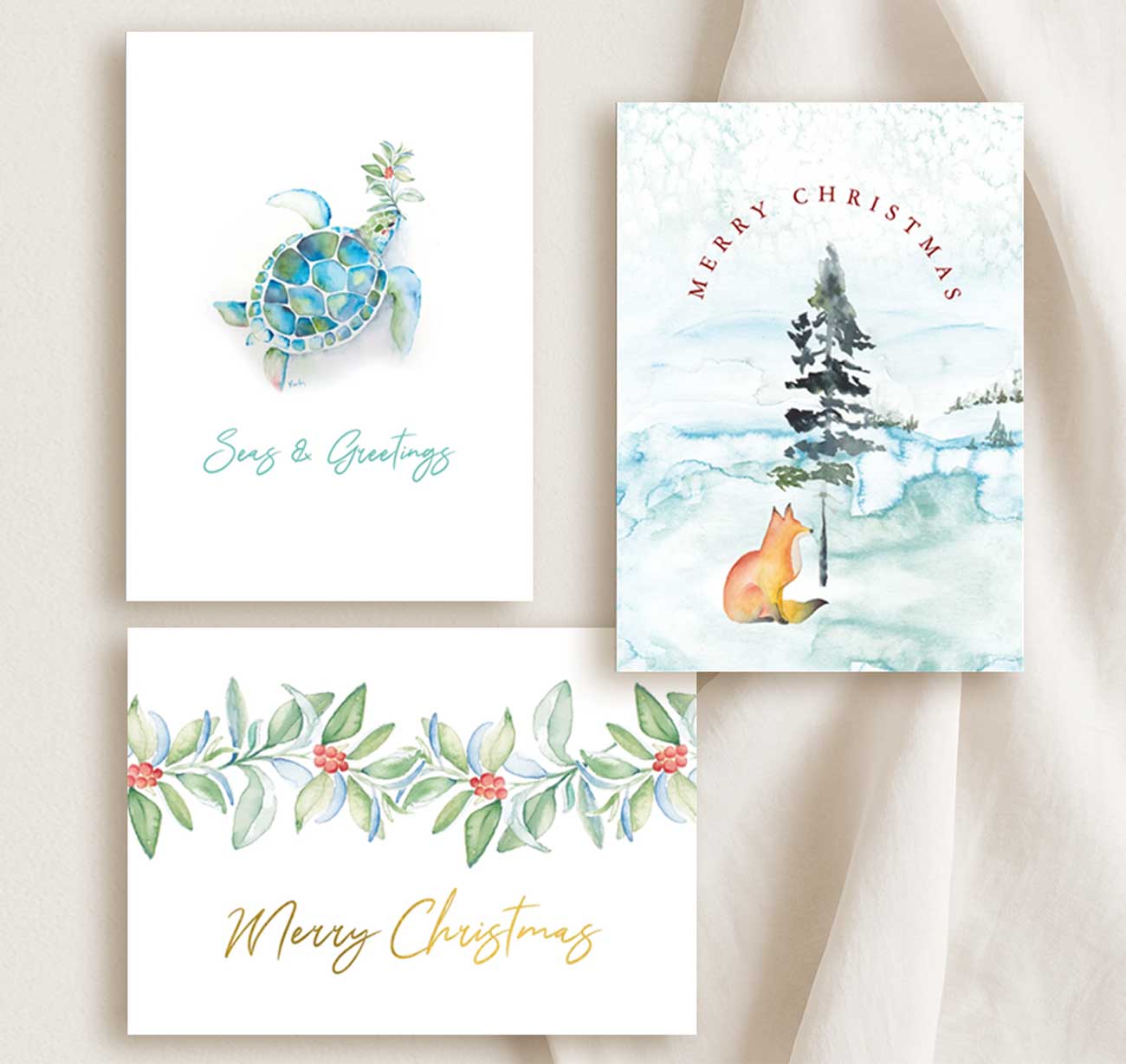 Watercolor Christmas cards features a flat lay of assorted xmas cards with hand painted art by small business owner Victoria of Do Tell A Belle.