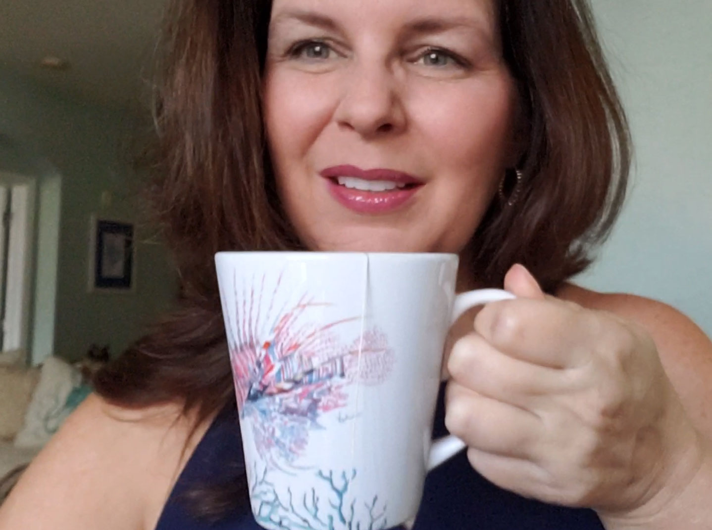 Victoria (Rigali) Grigaliunas of Do Tell A Belle holding her lion fish latte mug