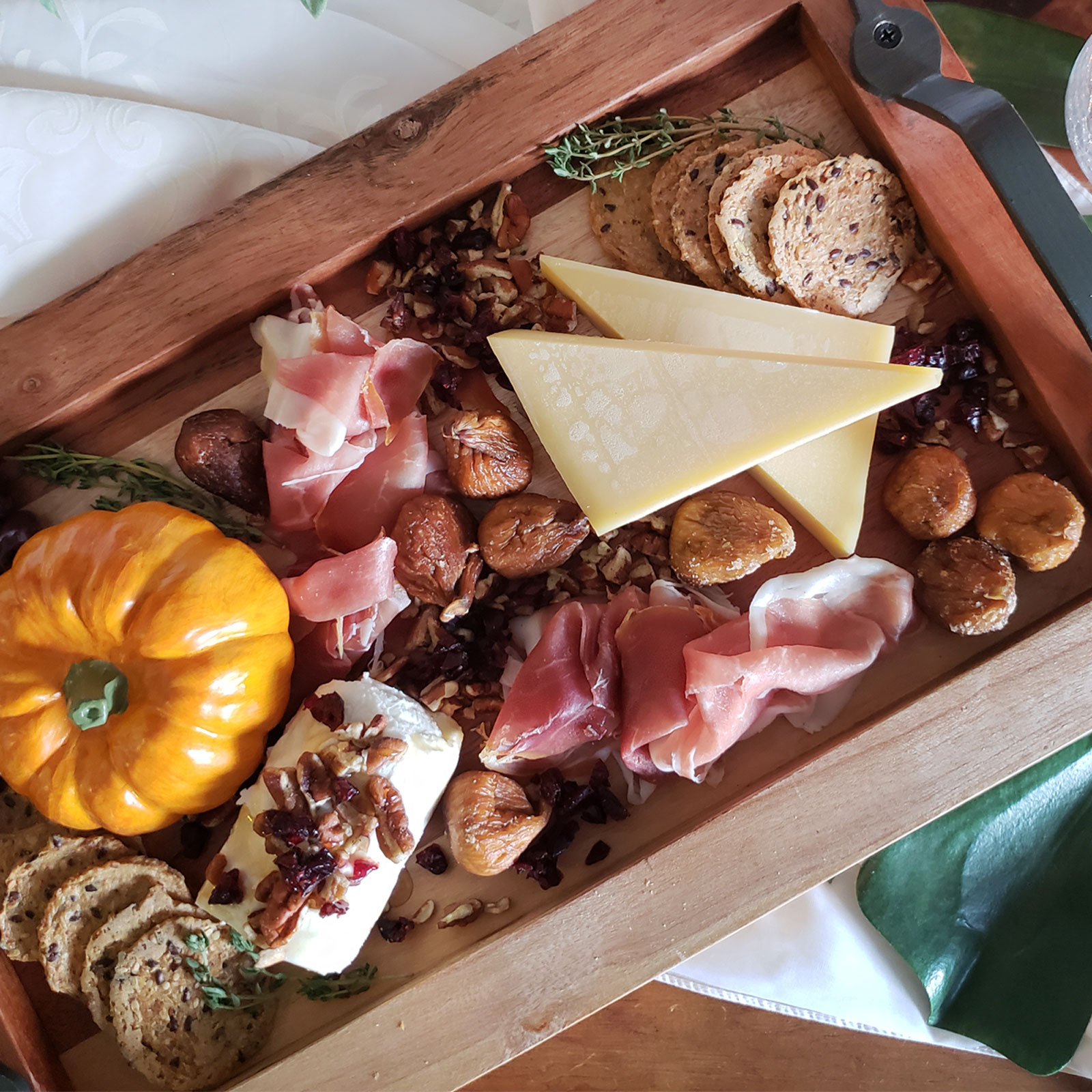 simple charcuterie for 2 recipe for fall with a pumpkin, goat cheese, nuts, cranberries, hard cheese, prochutto, crackers