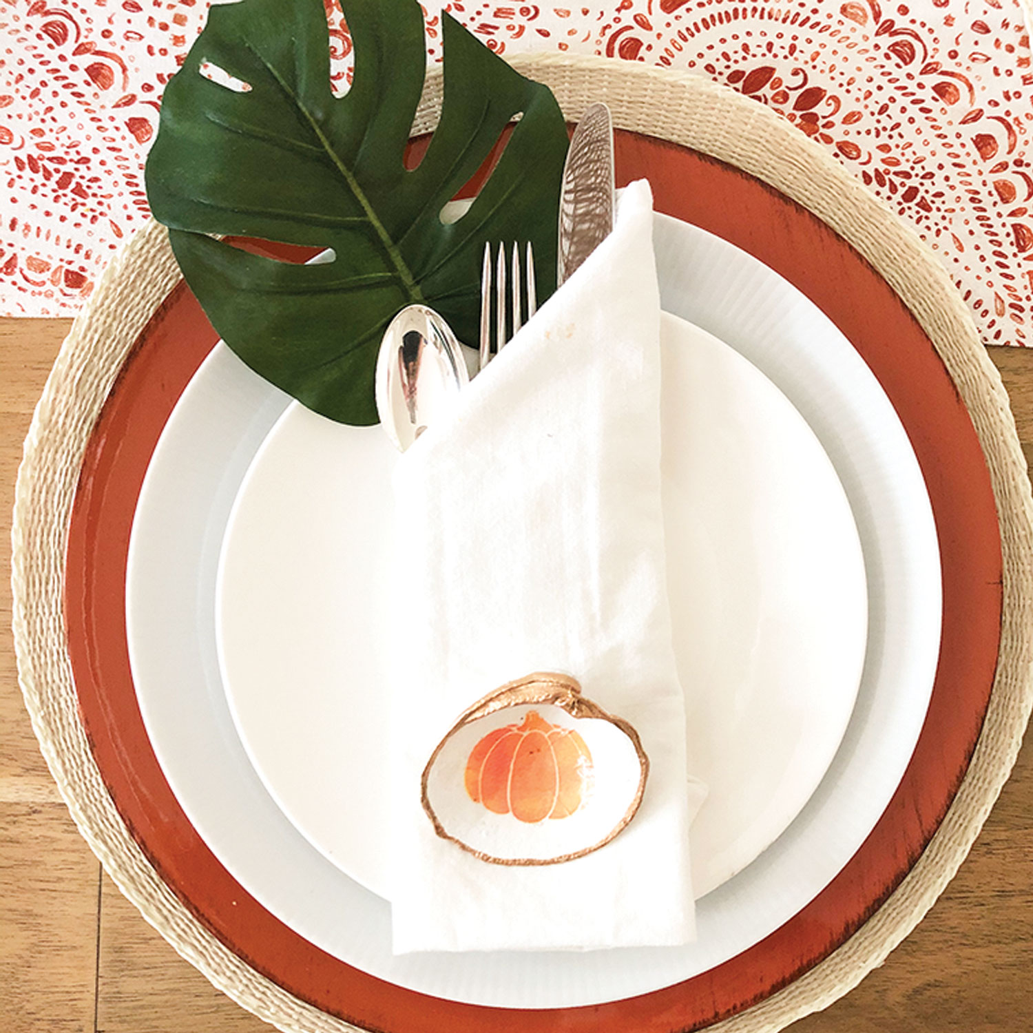 Palm Beach Thanksgiving tablescape with decoupage pumpkin shell and monstera leaf