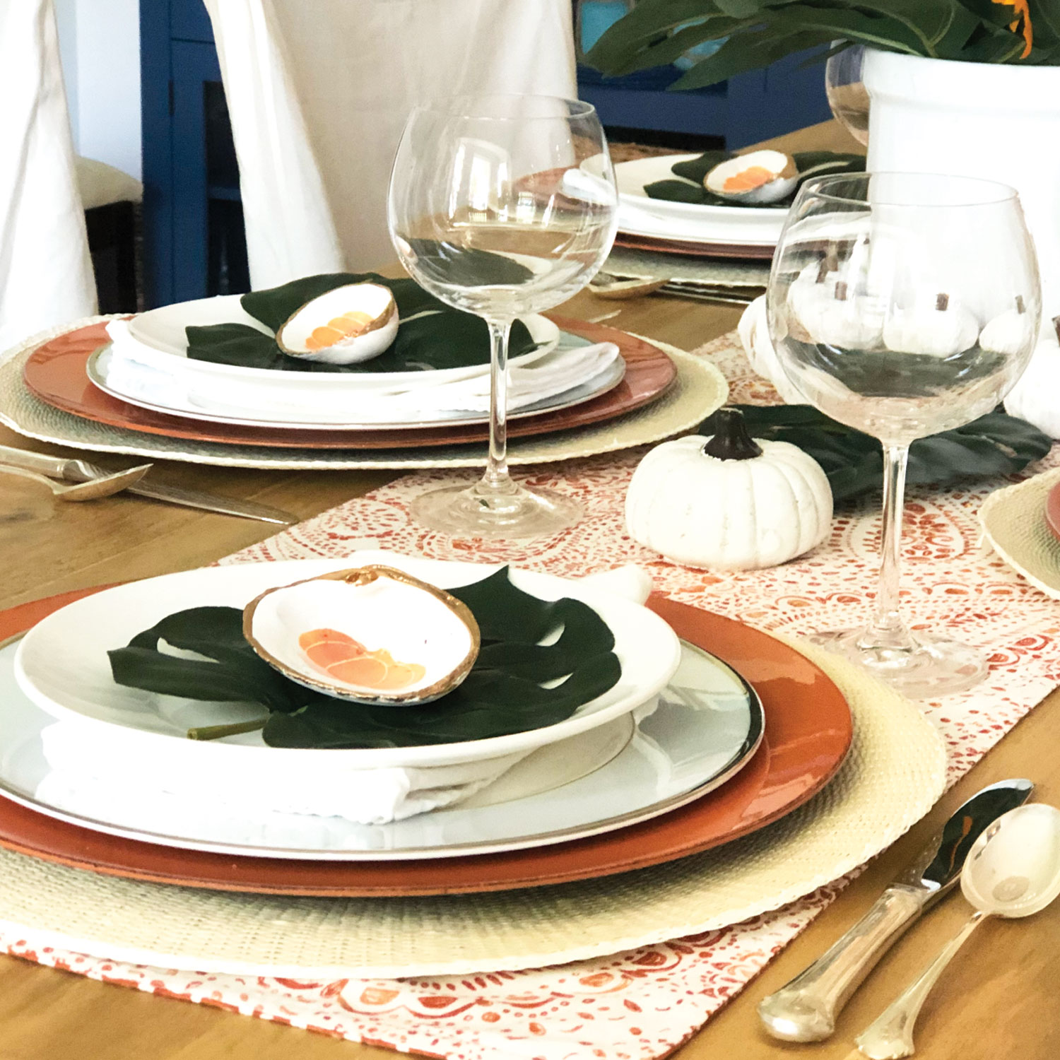 place setting with white pumpkin Palm Beach Thanksgiving tablescape with and monstera leaves