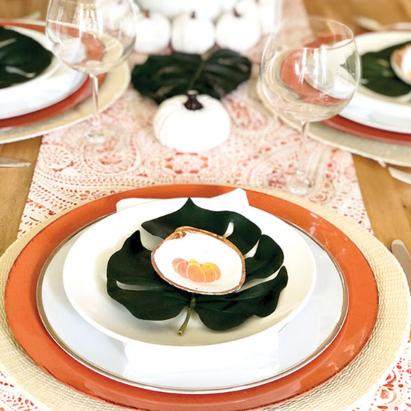 place setting with white pumpkin Palm Beach Thanksgiving tablescape with and monstera leaves
