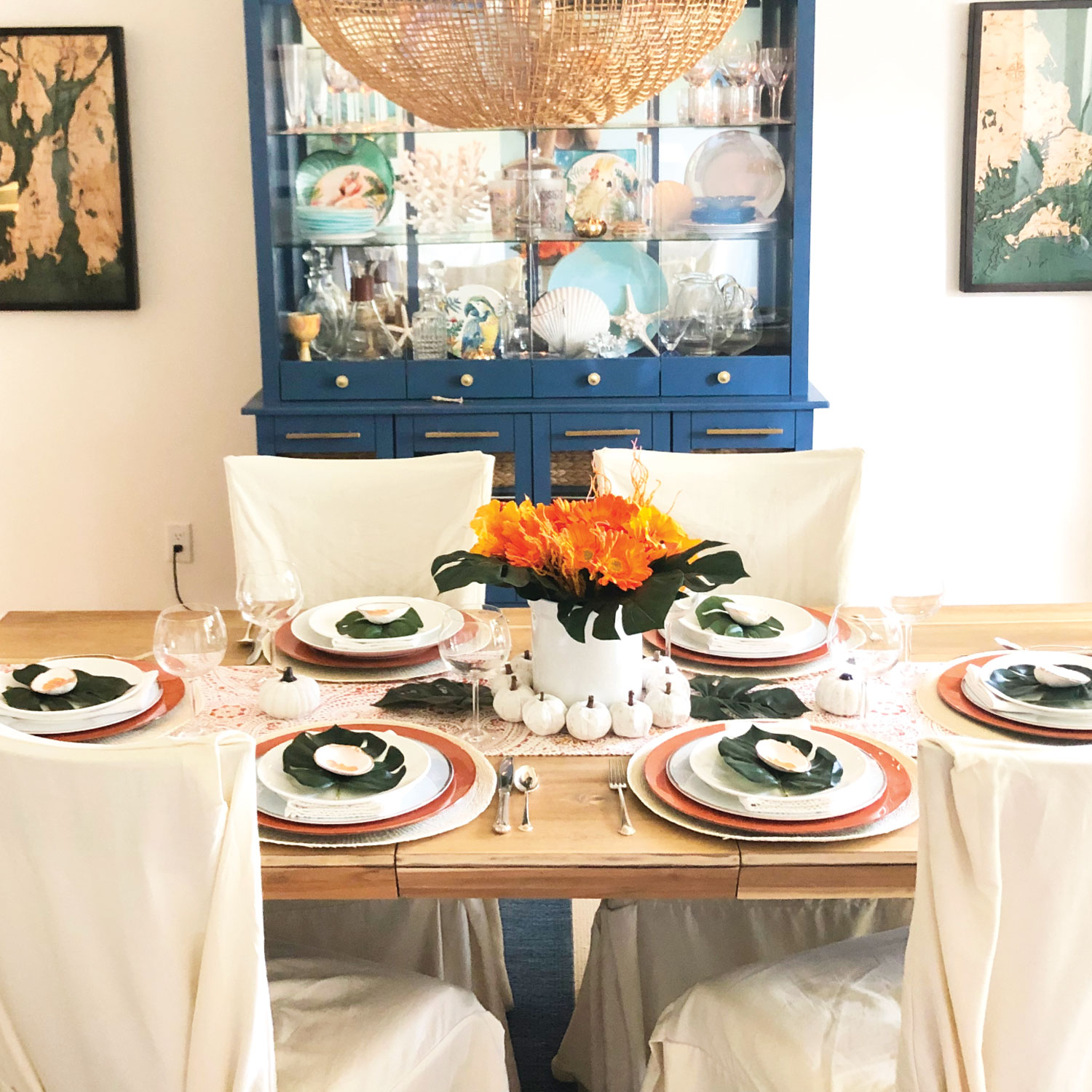 Seating for 6 Palm Beach Thanksgiving tablescape with orange flowers and monstera leaves