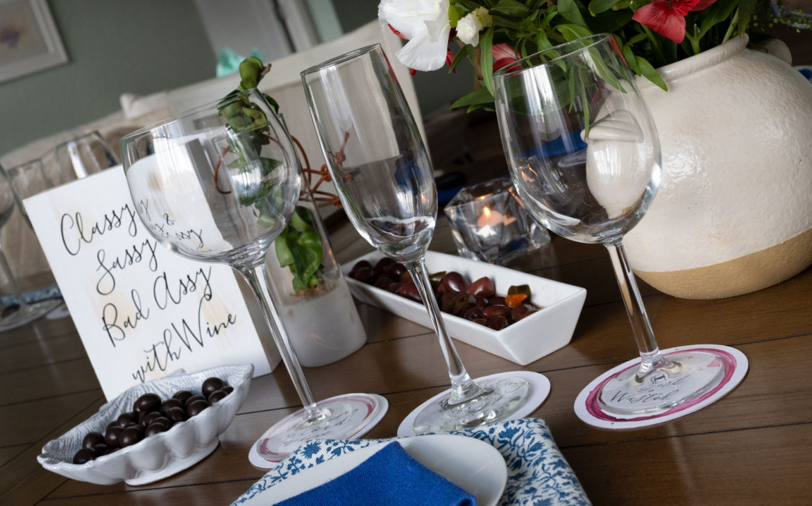 how to throw a wine tasting party. Set up place settings. Include wine glasses for each wine pairing along with a dish and napkin. 