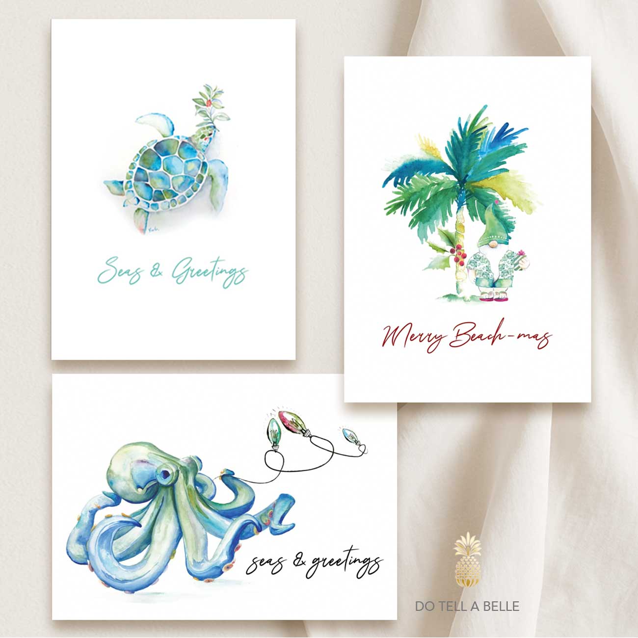 Three beach Christmas cards featuring hand-painted watercolor art by Victoria of Do Tell A Belle: a sea turtle with turquoise ocean hues, a tropical palm tree with the words ‘Merry Beach-mas,’ and a festive blue octopus design.
