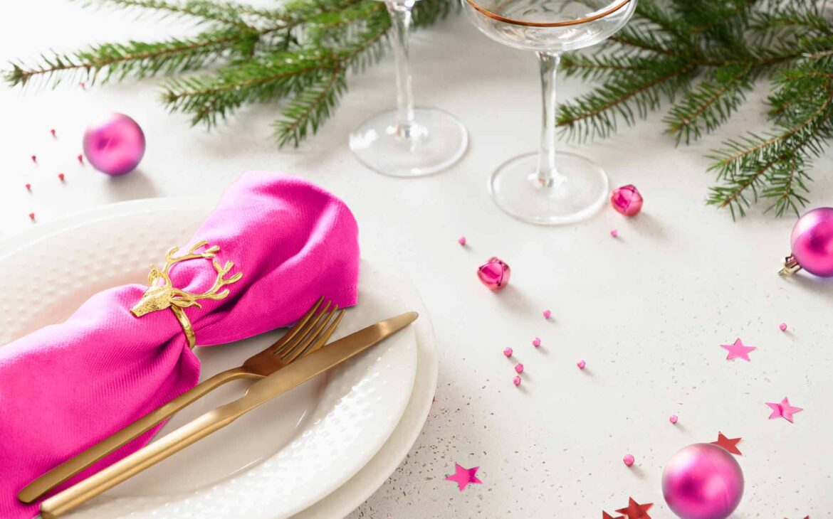 Unique Christmas baby shower ideas features vibrant pink and holiday greenery tablescape