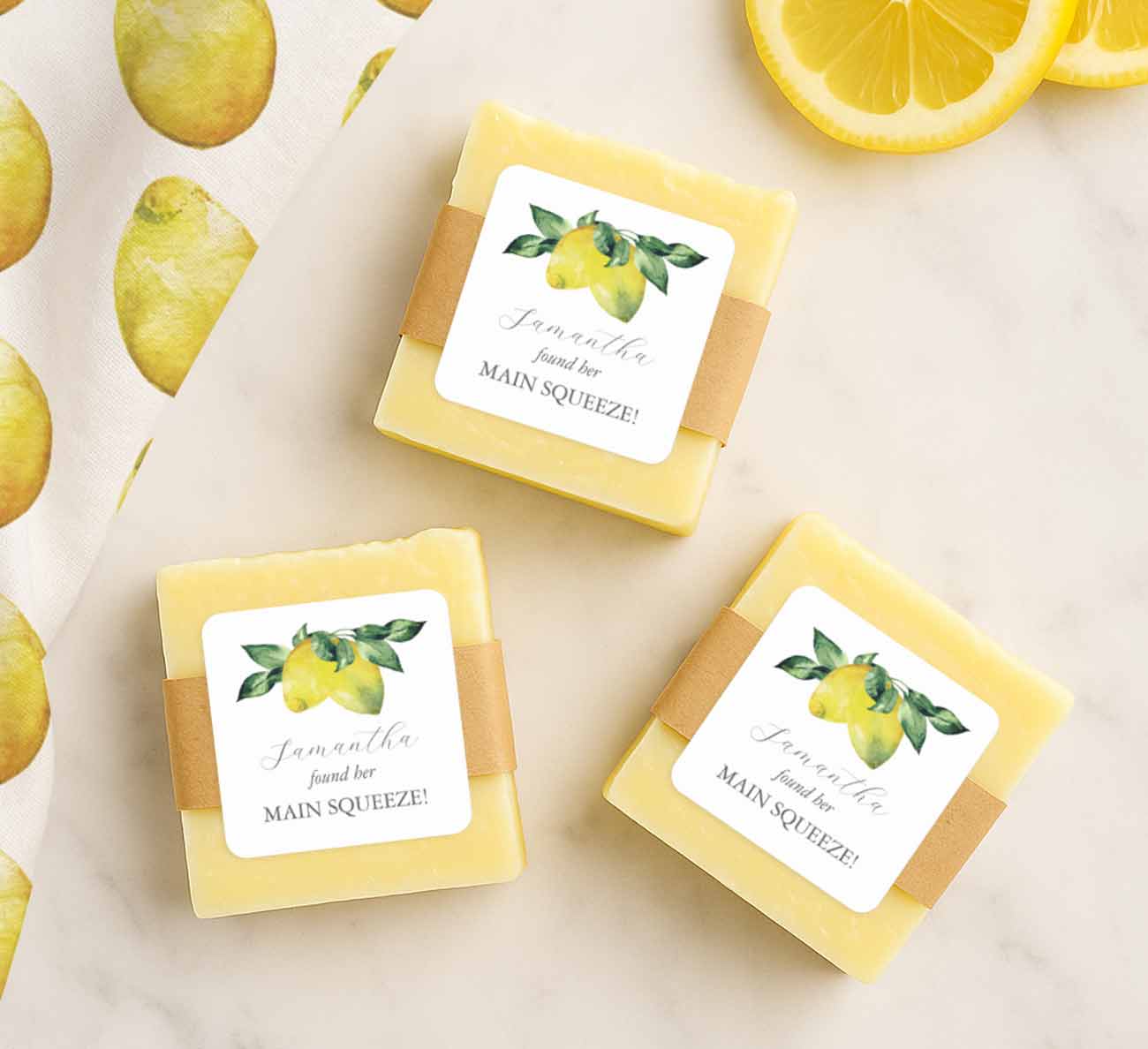 lemon bridal shower favors for bridal shower themes for summer feature a flat lay of hand made soap with personalized favor stickers that say main squeeze.