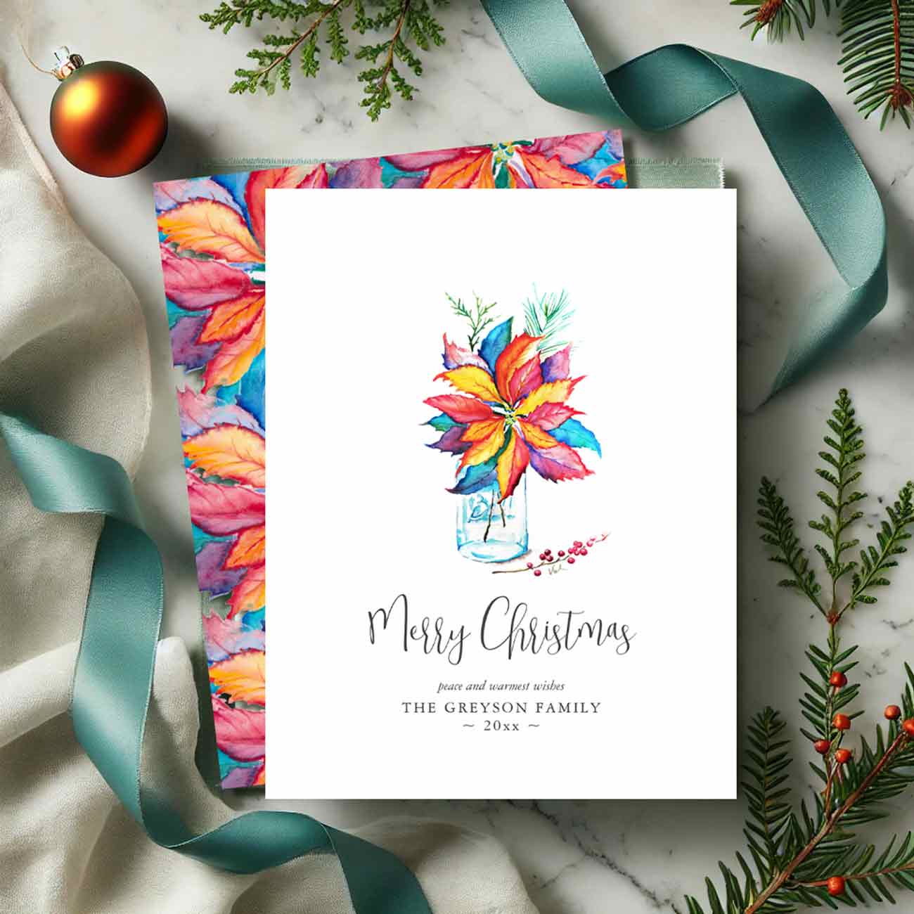 Flat lay of a creative Christmas party theme featuring a colorful watercolor poinsettia. Tap the button to shop the full theme. 