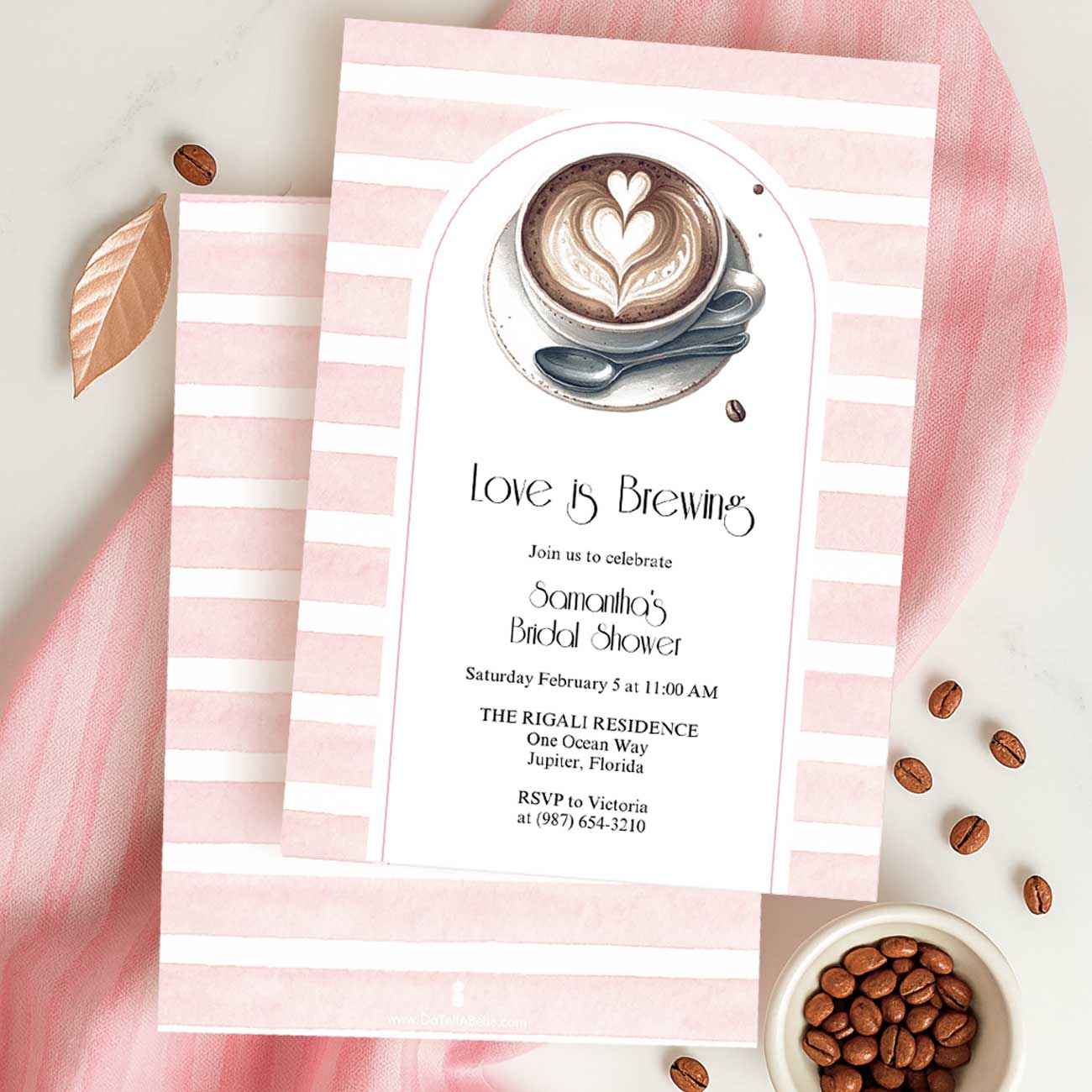 Flat lay of pink love is brewing bridal shower invitation with pink stripes and a cup of coffee with foam heart.