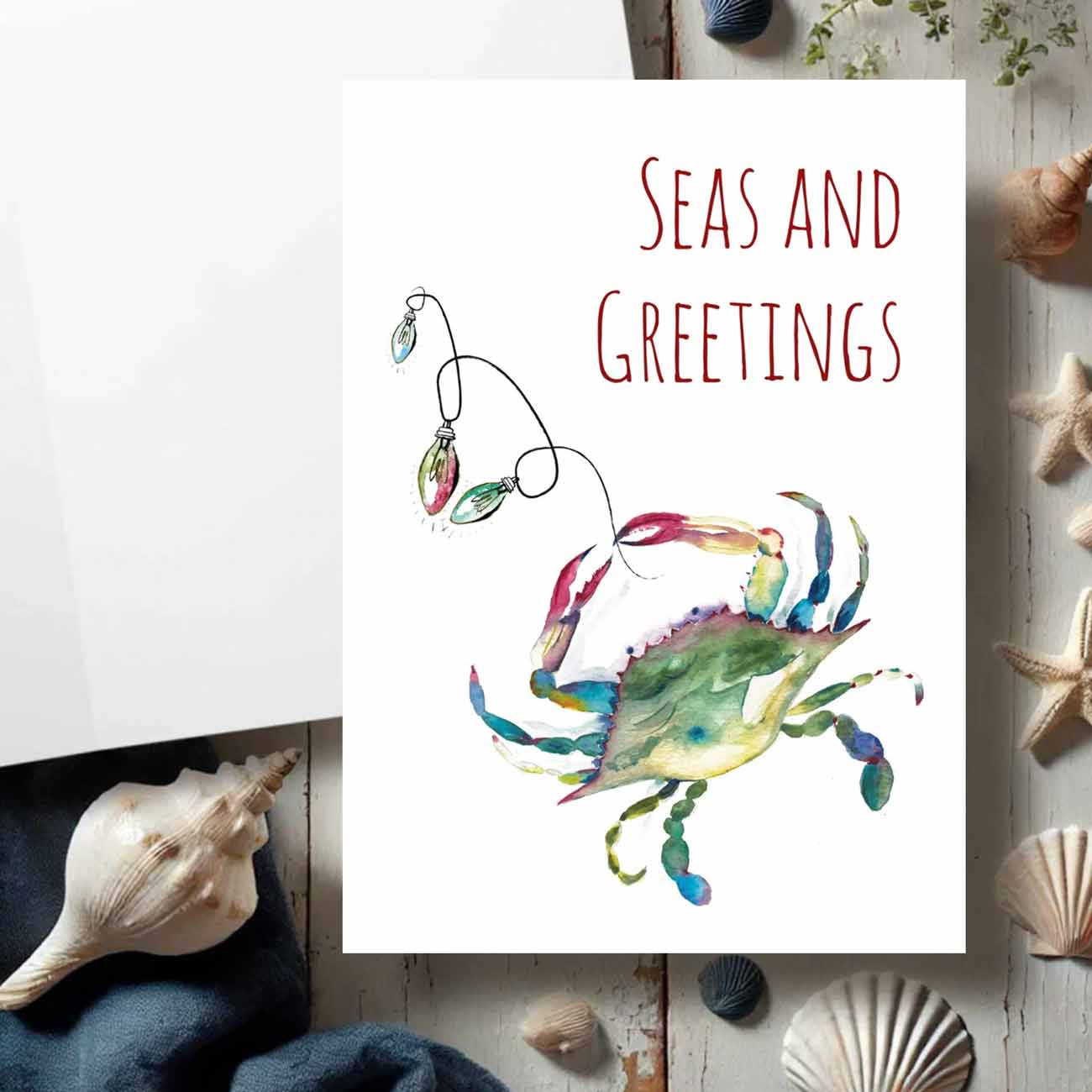 Coastal Christmas cards watercolor blue crab art by Victoria Grigaliunas of Do Tell A Belle a woman owned small business in South Florida. Tap to shop.