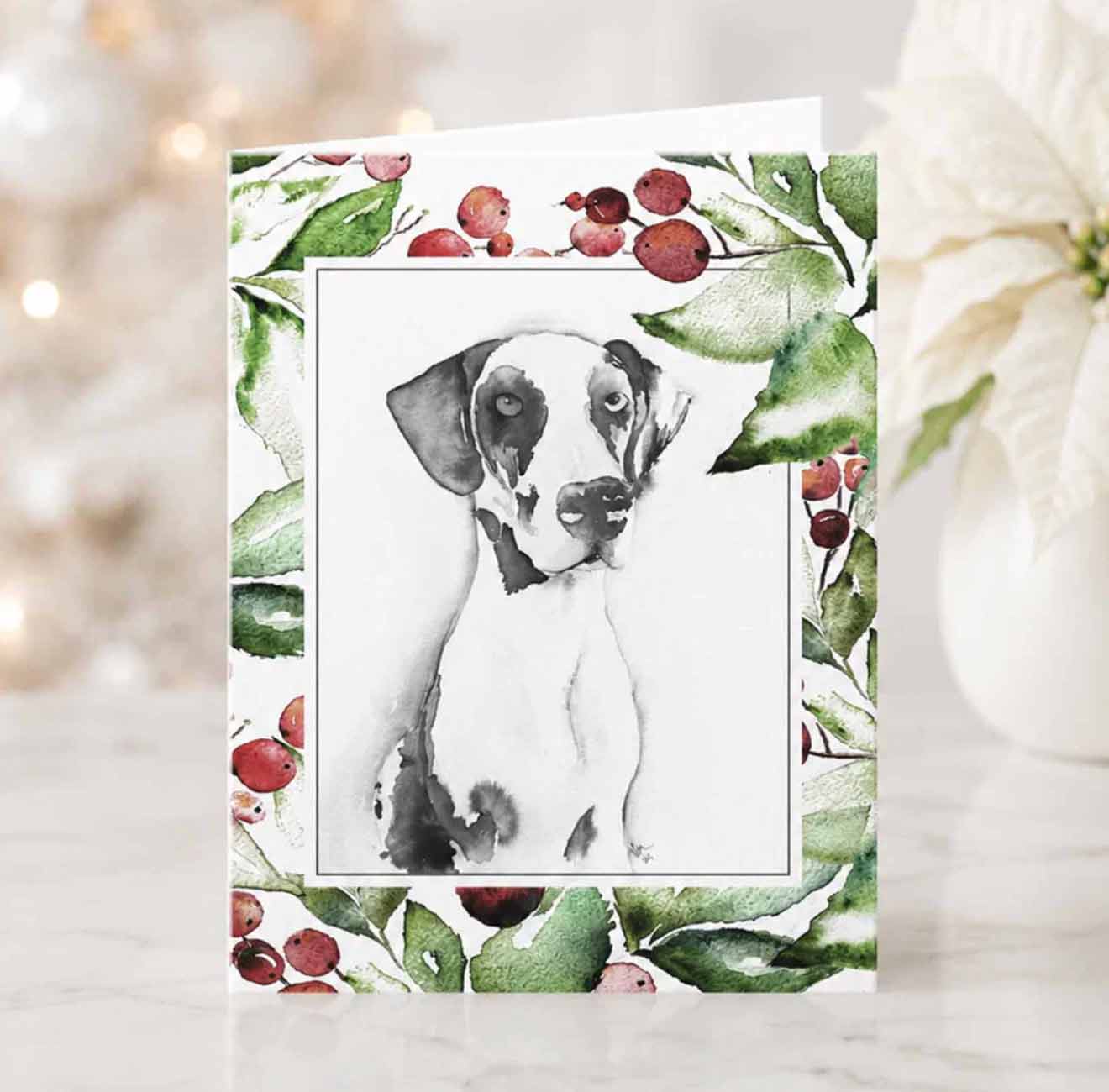 Dog watercolor Christmas card designed with a hand painted grate dane and a boarder of holiday botanicals in red and green by Victoria Grigaliunas of Do Tell A Belle.