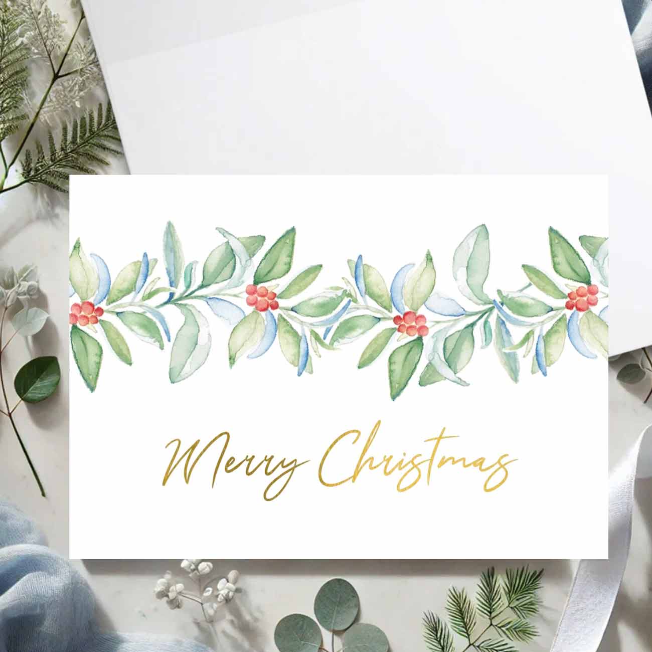 Flat lay of luxury watercolor Christmas cards by Florida artist Victoria Grigaliunas of Do Tell A Belle a woman owned small business. 