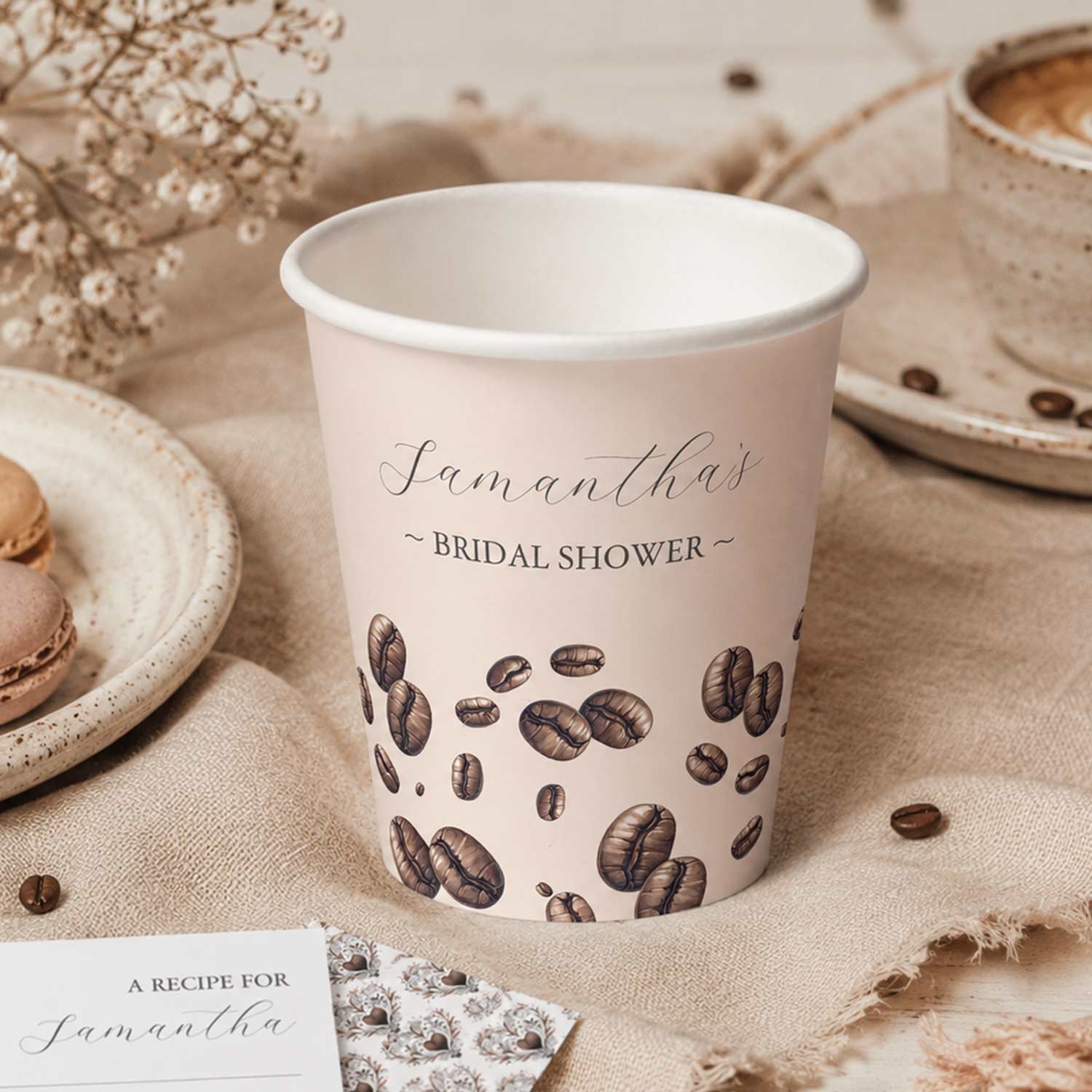 Love Is Brewing bridal shower coffee cup with illustrated coffee beans, coffee bar décor, recipe card, and café-inspired bridal shower decorations.
