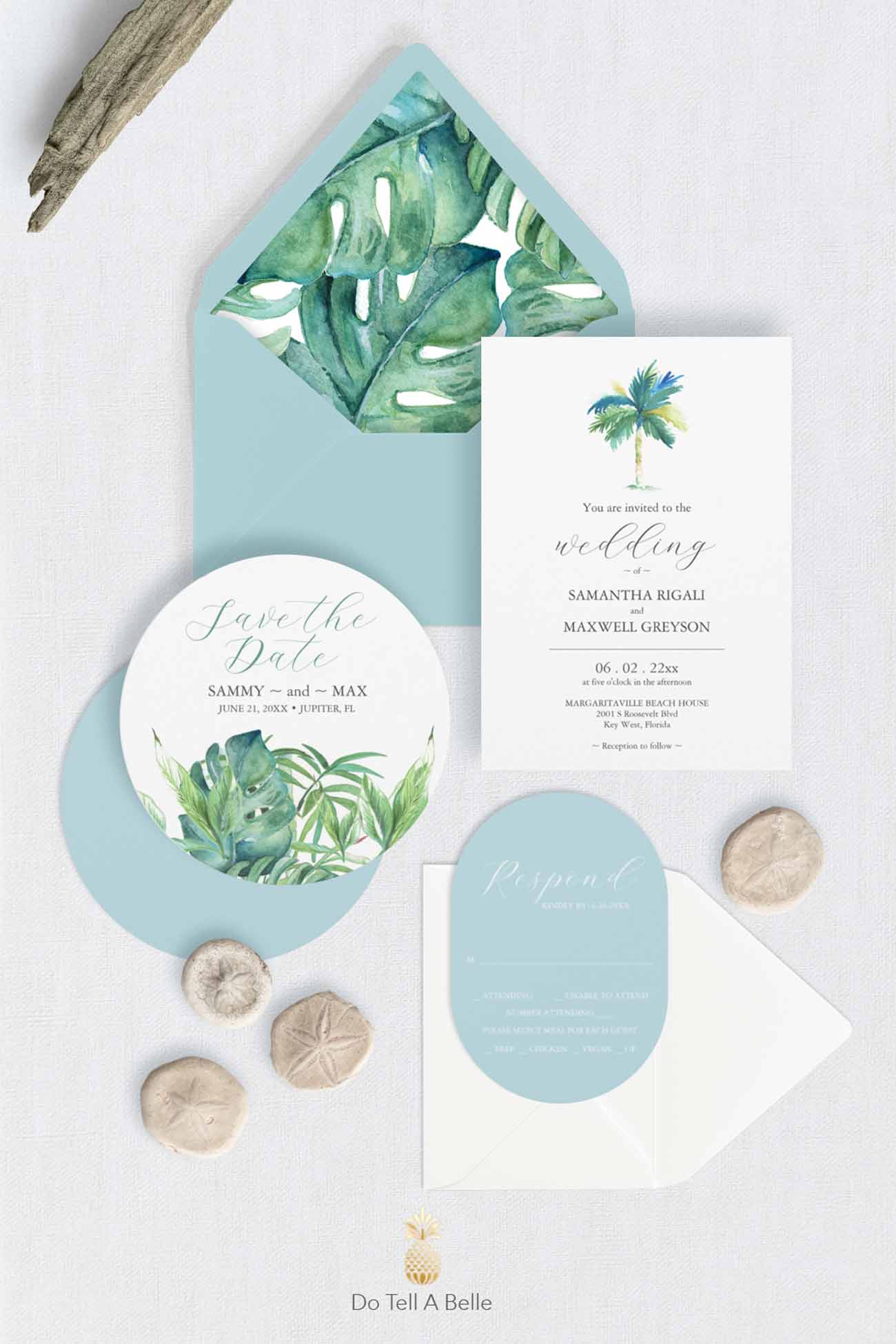 Tropical watercolor wedding stationery suite with palm trees, monstera leaves, powder blue envelopes, RSVP card, vellum wrap, and custom destination wedding invitation details by Do Tell A Belle