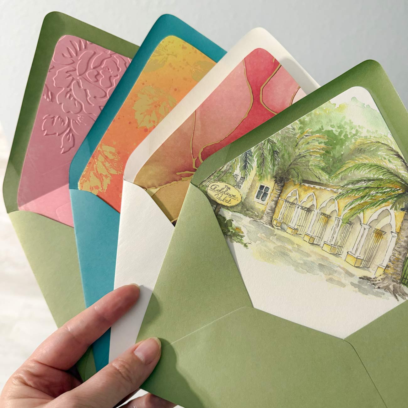 Custom wedding envelope liners with watercolor venue artwork, embossed details, floral patterns, and luxury wedding stationery designs