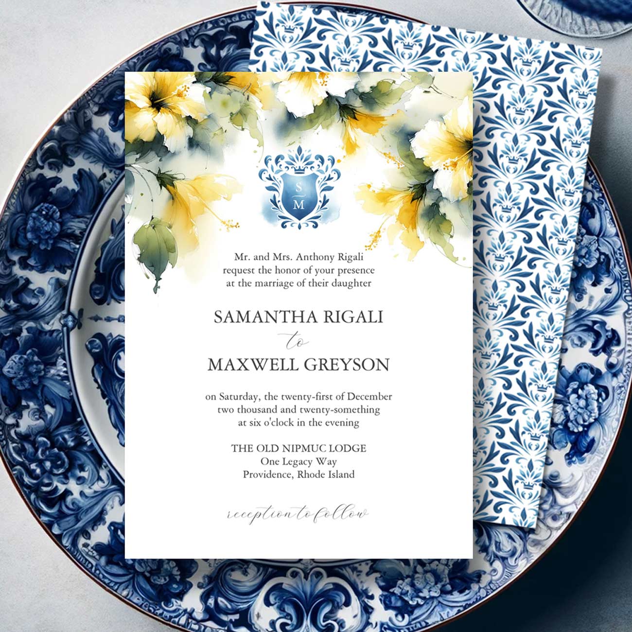 Formal wedding invitation featuring yellow hibiscus flowers, a blue monogrammed crest, and elegant tropical-inspired wedding stationery.