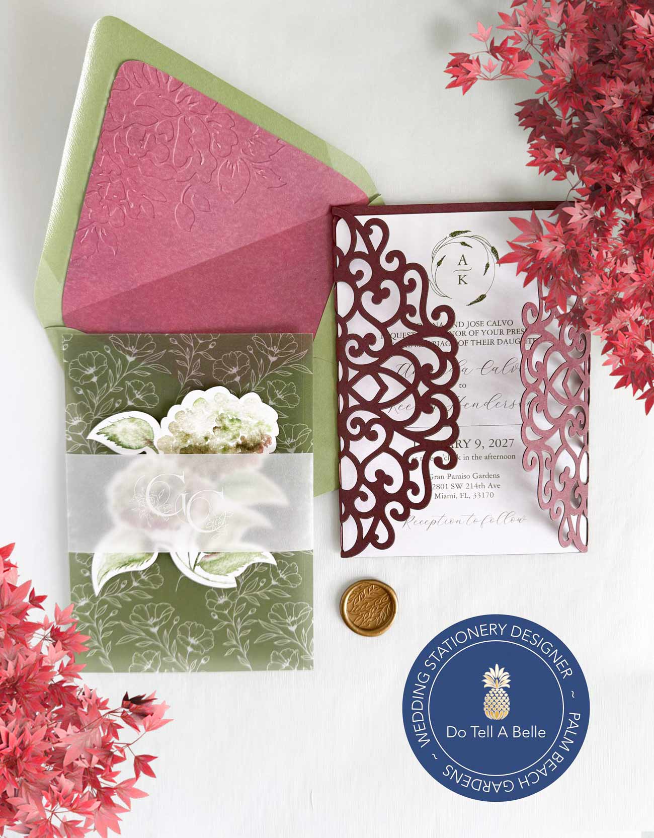 Semi custom die cut wedding invitations in burgundy and green featuring a gate fold invitation, die cut RSVP card, vellum overlay, vellum belly band, and embossed envelope liner.