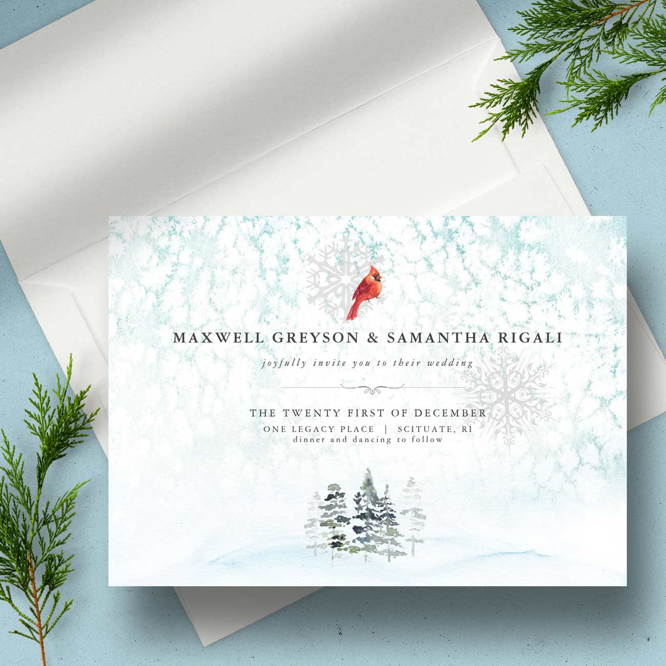 Winter wedding invitation featuring a watercolor snowy landscape with a red cardinal, pine trees, and elegant seasonal wedding stationery design.