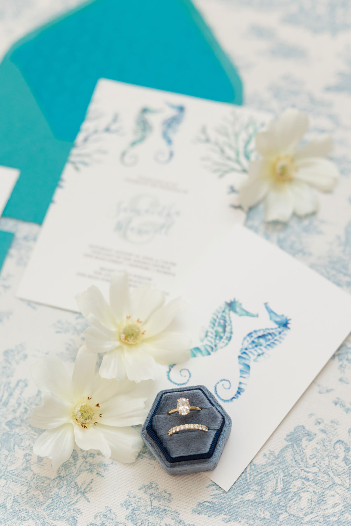 Watercolor beach wedding invitations with hand-painted seahorses and coral, turquoise envelope and embossed envelope liner.