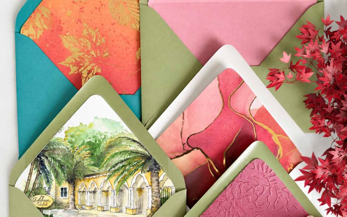 Colorful wedding envelope liners featuring original watercolor artwork, floral embossing, gold botanical patterns, and romantic pink designs, displayed in sage green and teal envelopes. Custom wedding stationery by Do Tell A Belle.